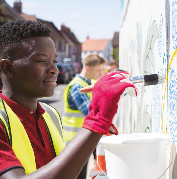 A student painting a mural on a wall